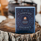 Card deck titled 'Campfire Stories' on a wooden stump with a snowy background