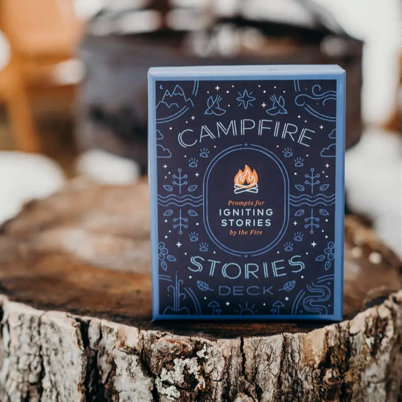 Card deck titled 'Campfire Stories' on a wooden stump with a snowy background